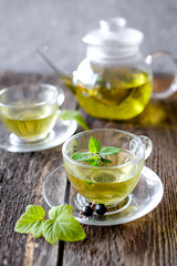  Green herbal tea with a berries in glass cup on wooden table background