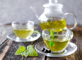  Green herbal tea with a berries in glass cup on wooden table background