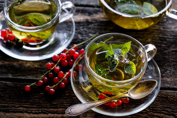  Green herbal tea with a berries in glass cup on wooden table background