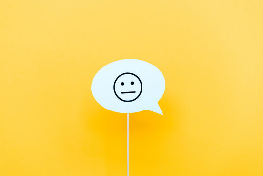 KYIV, UKRAINE - AUGUST 5, 2019: upset face on speech bubble on orange