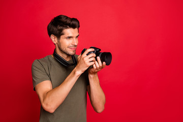 Photo of amazing guy with photo digicam making pictures wear casual grey t-shirt isolated on red background