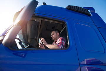 Truck driver sitting in his truck and setting up coordinates for navigation. Transportation...