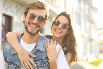 Beautiful young couple in love walking outdoors at the city street, hugging.