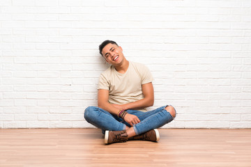 Young man sitting on the floor laughing