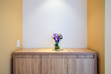 Flower in a glass vase on wooden table in hotel room