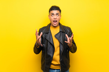 Young man over isolated yellow background frustrated by a bad situation