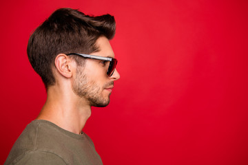Profile photo of amazing guy looking empty space not smiling wear grey t-shirt isolated on red...