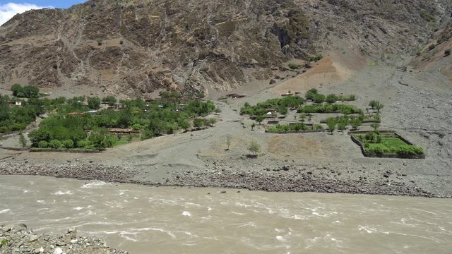 Kulob to Qalai Khumb Pamir Highway along the Panj River with View of a Village on the Afghanistan Side on a Sunny Blue Sky Day