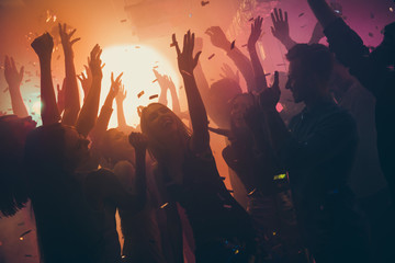 Fototapeta na wymiar Photo of many party people buddies dancing yellow lights confetti flying everywhere nightclub event hands raised up wear shiny clothes