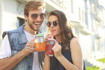Beautiful young couple in love walking outdoors at the city street.