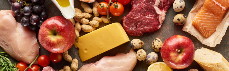 Panoramic shot of raw meat, poultry and fish with cheese, peanuts, fruits and vegetable