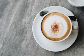 Hot coffee and hot tea place on the marble table in early morning with copyspace, white cup and silver spoon.