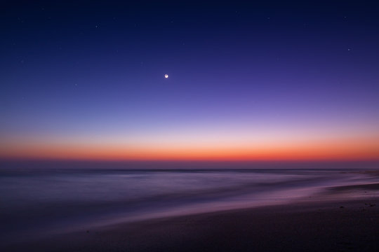 Long exposure on the beach one evening with the month before sunrise