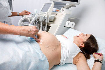 Joyful pregnant woman received good news doing obstetric ultrasonography