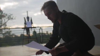 Man working with documents on balcony of country house