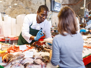 Salesman serving customer raw fish