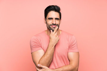 Handsome young man over isolated pink background laughing