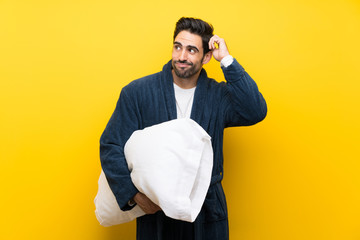 Handsome man in pajamas having doubts and with confuse face expression