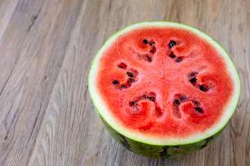 Half of fresh red watermelon on wooden table