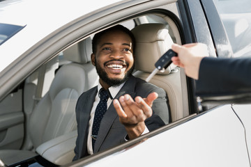 Test drive new car. Young businessman taking auto key