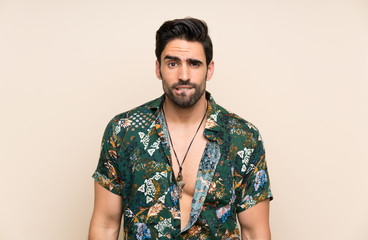 Obraz premium Handsome man in summer shirt over isolated background having doubts and with confuse face expression