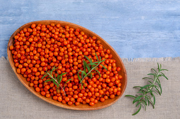 Large sea buckthorn berries with rosemary branches.