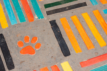 Ceramic tile flooring and dog foot print. Construction material texture.