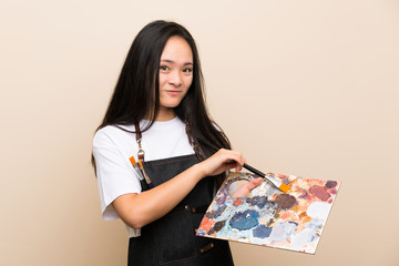 Teenager painter asian girl over isolated background