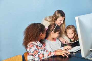 Lehrerin hilft Kindern am Computer