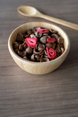 homemade granola with milk for breakfast on wooden table with soft-focus and over light in the background