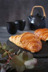 Two fresh croissants and teapot