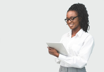 African American Woman Reading Something On Tablet Computer In Studio