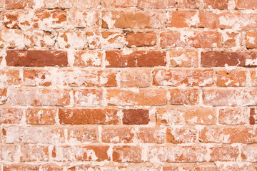 Old orange brick wall with cracks on the bricks. shabby vintage wall