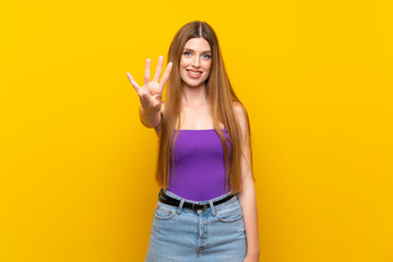 Young woman over isolated yellow background happy and counting four with fingers