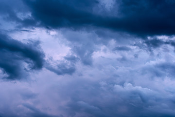 Naklejka na ściany i meble Blue hour sky clouds background. Beautiful landscape with stormy clouds and purple sun on sky
