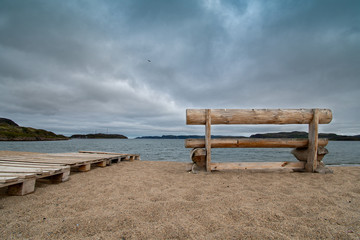 Fototapeta na wymiar Lonely bench by the sea in autumn