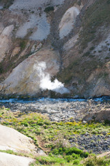 Active volcano, turquoise lake and river, sulphurous fumes in unique white sand desert mountains in Patagonia, Chile. Sunny sky, white mountains. Backpacking, hiking and camping on Condor Circuit 