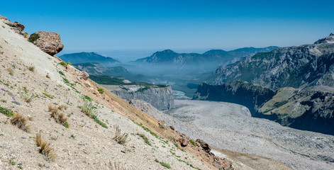 Active volcano, turquoise lake and river, sulphurous fumes in unique white sand desert mountains in Patagonia, Chile. Sunny sky, white mountains. Backpacking, hiking and camping on Condor Circuit 
