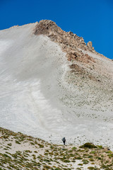 A young woman with backpack in unique white sand desert mountains in Patagonia, Chile. Sunny sky,...