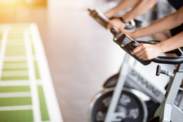 Closeup image of hands holding the handlebars of the bike machine. Burn out cardio, fatburn, Gym and fitness.