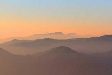 Beautiful Sunset and sunrise on sky and golden twilight time with mist and fog in valley of mountain layer