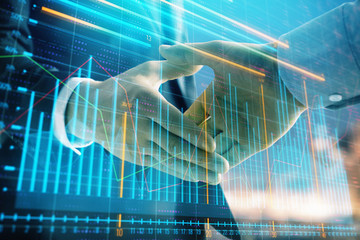 Double exposure of financial chart on cityscape background with two businessmen handshake. Concept of financial analysis and investment opportunities