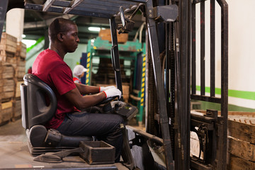 Afro male driver working on forklift