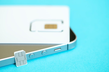 micro and mini SIM card and smartphone on blue background