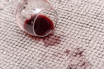 Glass with Red Wine on the Floor, Red Wine spilled on a Carpet, stains and spots by Beverage, close-up