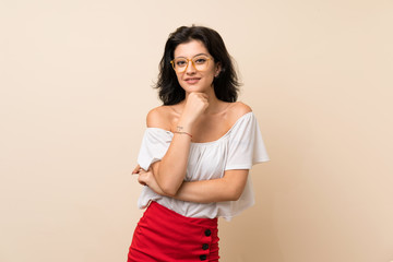 Young woman over isolated background with glasses and smiling