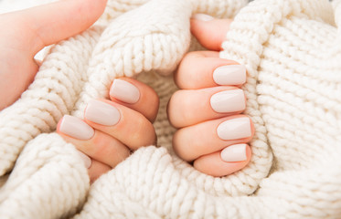 pastel beige Nails holding knitted wool material