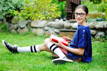 Teen girl with book in the park