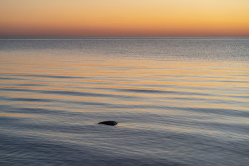 Fototapeta na wymiar Stone cairn on the Baltic Sea with waves