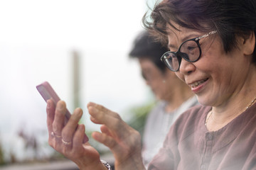 Happy elderly senior people society lifestyle technology concept. Ageing Asia women using tablet...